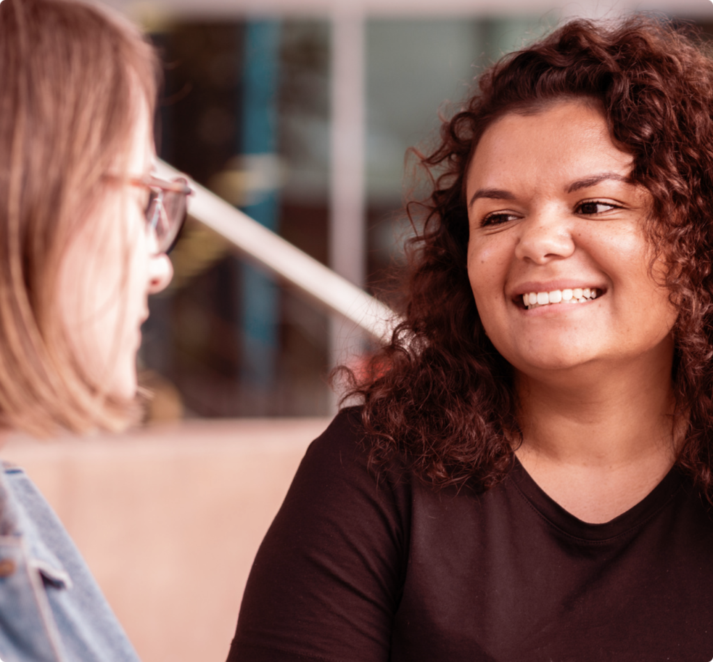 Two women having a conversation and smiling at each other